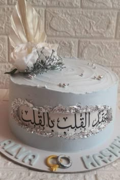 a wedding cake decorated with silver and white frosting