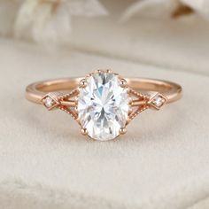 a rose gold engagement ring with an oval cut diamond in the center