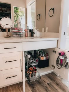 an open cabinet in a bathroom next to a counter with makeup and other items on it