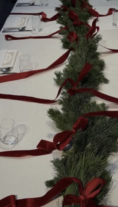 the table is set with red ribbon and place settings