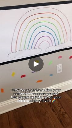 a child's room with a rainbow painted on the wall and a video play button