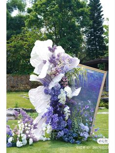 an easel with flowers on it in the grass