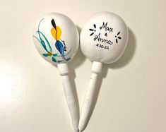 two white lollipops with designs on them