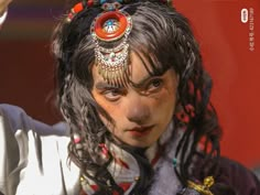 a close up of a person wearing a head piece with beads and chains on it