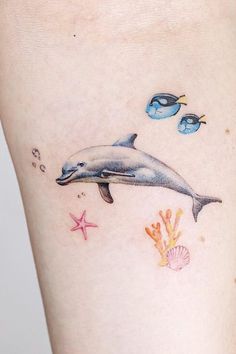 a dolphin and starfish tattoo on the right side of the leg, with an ocean theme