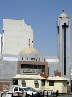 two police cars parked in front of a building with a dome on top and a clock tower behind it