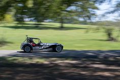 a buggy driving down the road with trees in the background