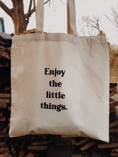 "Enjoy the Little Things Canvas Tote Market Bag This minimalistic tote bag is sturdy and durable. This eco-friendly reusable bag and can withstand the wear of daily use. They make for a great book tote, grocery tote, car tote, and so much more. Take this bag with you to the Farmer's Market, bookstores, picnics, the beach, and so on! The simplistic design makes for great daily use. This item is screen printed using black ink. Each bag is screen printed on one side and is machine washable. They ar Coconut Branding, Tote Bag Sayings, Random Diys, Halloween Tee Shirts, Quote Tote Bag, Bag Quotes, Funny Tote Bags, Stencils Printables