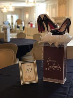 a pair of high heeled shoes sitting on top of a table next to a bag