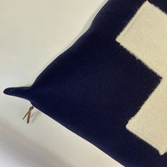 a blue and white pillow sitting on top of a bed next to a wooden stick