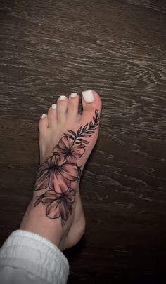 a woman's foot with a flower tattoo on her left side and the bottom part of her toe