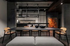 a table and chairs in a room with black walls