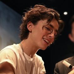 a young man smiling while holding a microphone