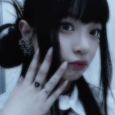 a woman with black hair and ring on her finger