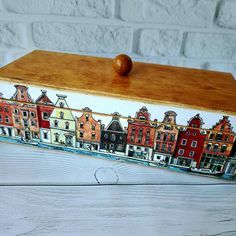 a wooden box painted with buildings on it