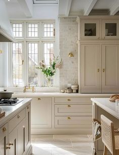 a large kitchen with white cabinets and marble counter tops