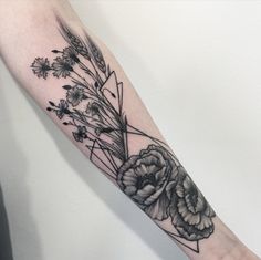 a black and white flower tattoo on the arm