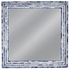 a square mirror with blue and white tiles on the border, in front of a white background