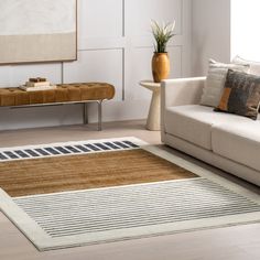 a living room with white couches and brown rugs on the floor next to a coffee table