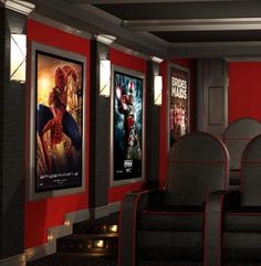 an empty movie theater with red walls and posters on the wall