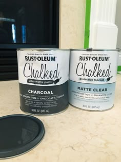 two cans of white chalk sitting on top of a counter next to a black pan