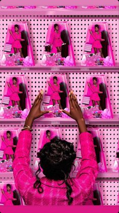 a woman in pink is holding her hands up to the ceiling with mirrors behind her