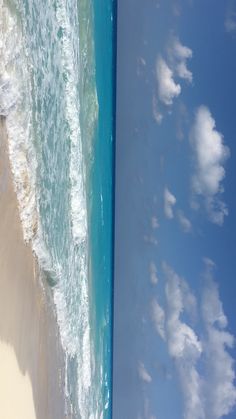 an aerial view of the beach and ocean with waves coming in from the shore line