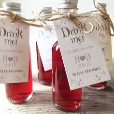 three bottles filled with red liquid sitting on top of a table