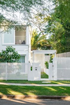 a white fence and gate in front of a house