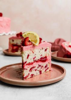 a slice of strawberry cake on a pink plate with a lemon wedge in the middle