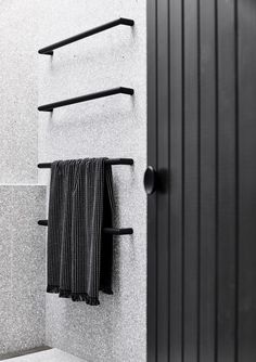 a black towel hanging on the wall next to a door