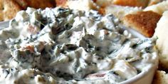 a close up of a bowl of food with bread in the background