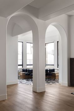 an empty room with arched windows and wooden floors