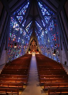 an empty church with stained glass windows and pews