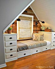 an attic bedroom with white drawers and storage underneath the bed is decorated in wood planks