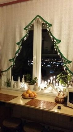 a decorated christmas tree sitting on top of a kitchen counter next to a microwave oven