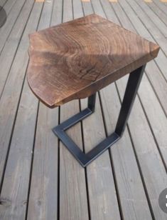 a small wooden table sitting on top of a wooden floor next to a black metal frame