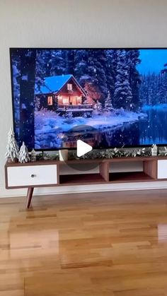 a flat screen tv sitting on top of a wooden entertainment center in a living room