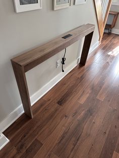 a wooden bench sitting on top of a hard wood floor next to a stair case