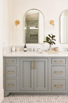 a bathroom with two sinks and mirrors on the wall, along with a tiled floor