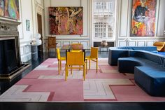 a living room filled with furniture and a fire place in front of a painting on the wall