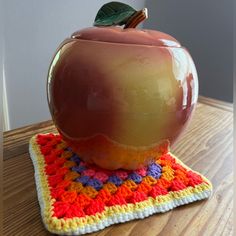 an apple sitting on top of a crocheted placemat