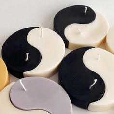 several candles with yin symbols on them sitting next to each other in front of a white background