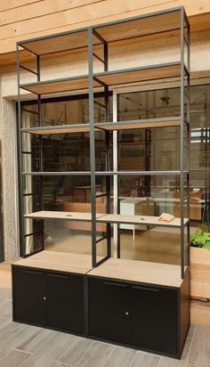 an empty display case in front of a building with plants growing out of the windows