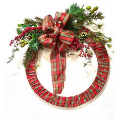 a christmas wreath with red and green plaid ribbon