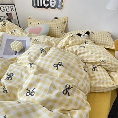 a bed covered in yellow and white checkered sheets with an animal on it,