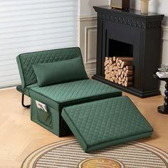 a green chair and ottoman sitting in front of a fire place with logs on the floor