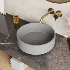 a bathroom sink with a circular bowl on the counter top and gold faucet