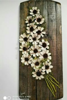 a bunch of white flowers sitting on top of a wooden board