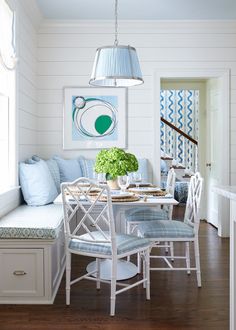 a white dining room with blue and green decor